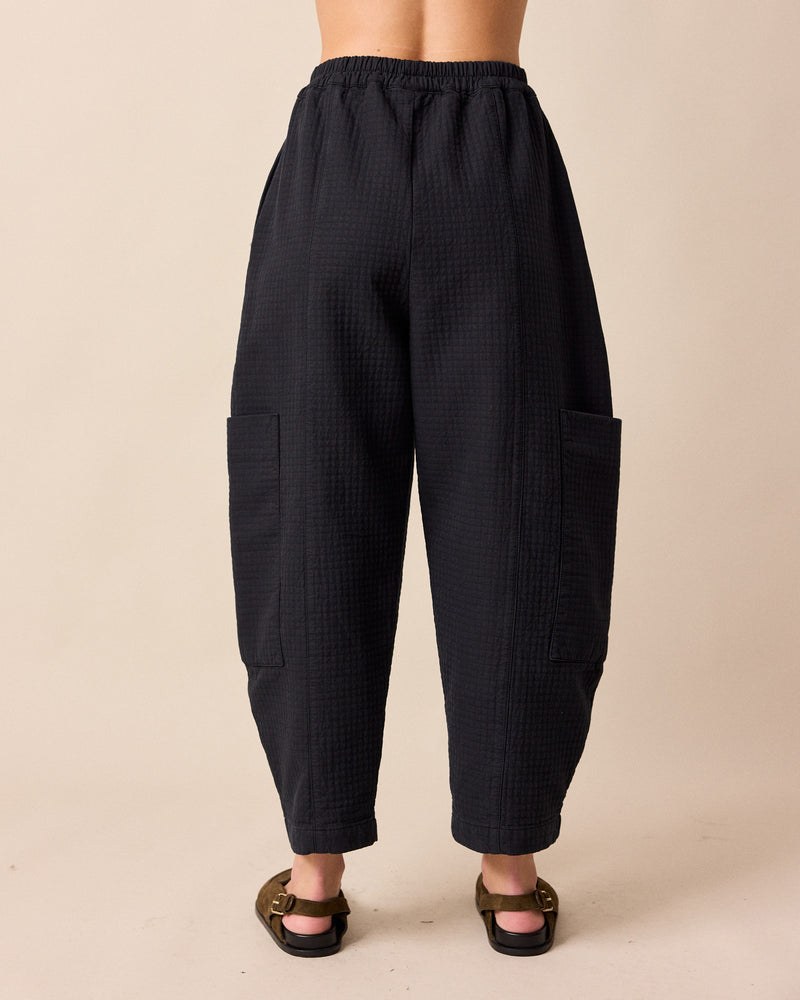 model wears amala black quilted cotton trousers back