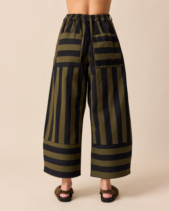 model wears blair olive and black stripe denim trousers back