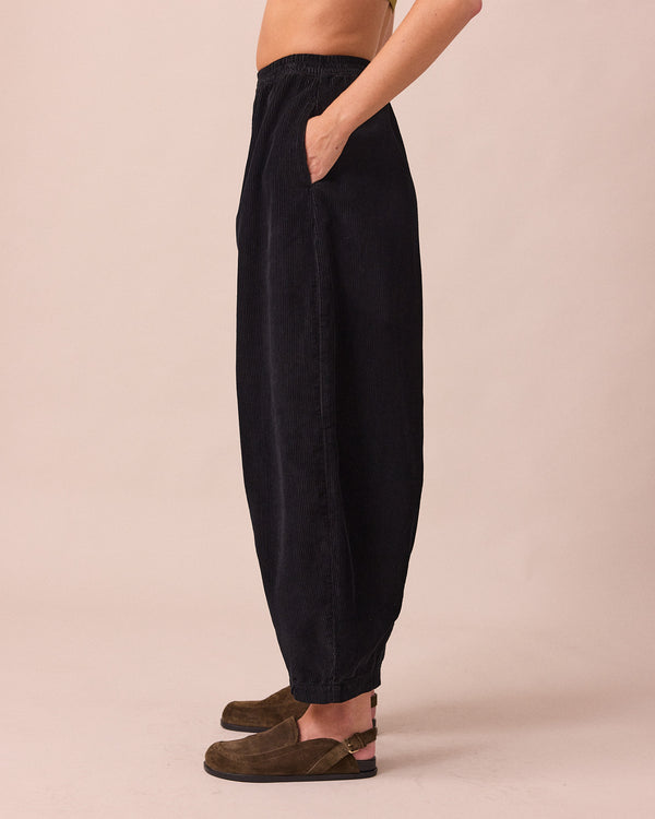 model wears daisy black cord trousers left