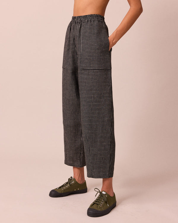 model wears huxley black mini grid linen trousers left
