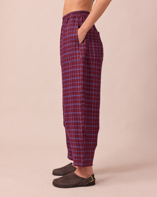 model wears huxley mulberry plaid linen trousers left