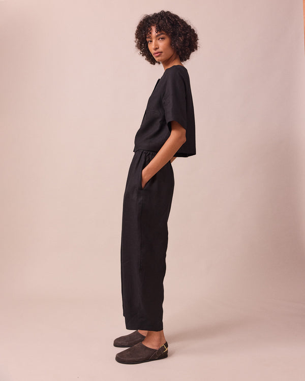 model wears mabel black linen trousers left