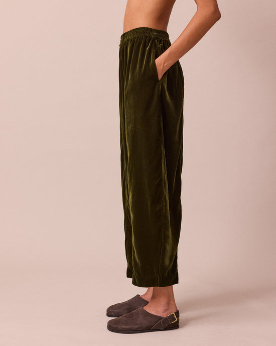 model wears mabel moss green velvet trousers left