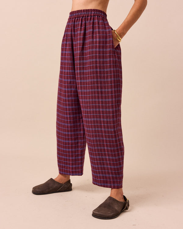 model wears mabel mulberry check linen trousers left