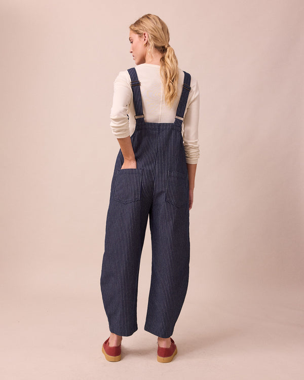 model wears ottie navy pinstripe denim jumpsuit