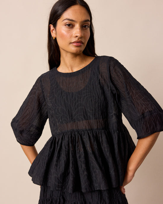 model wears priya black organza top