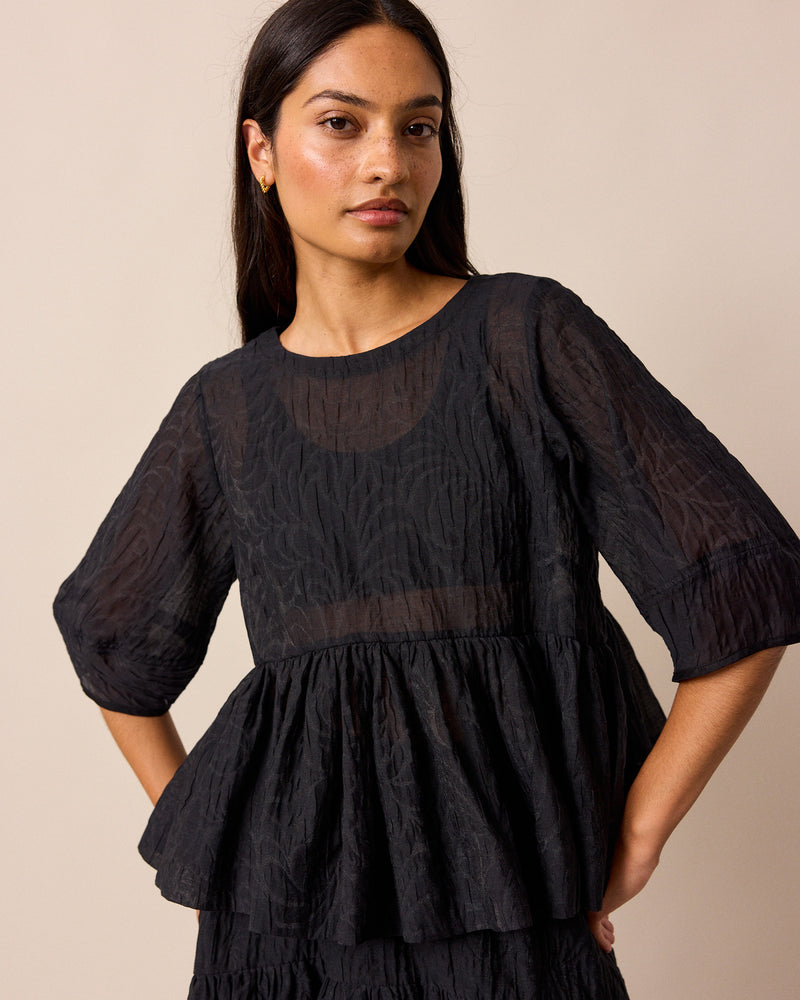 model wears priya black organza top