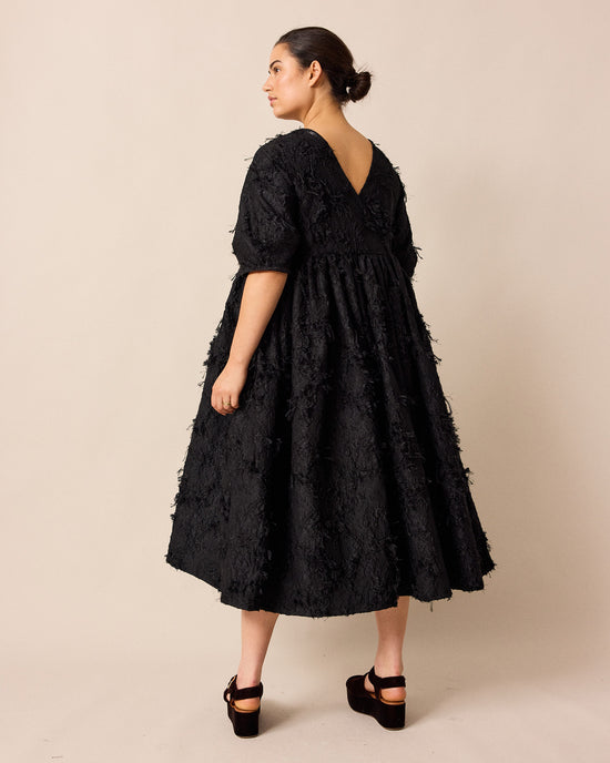 model wears prue black tufted dress