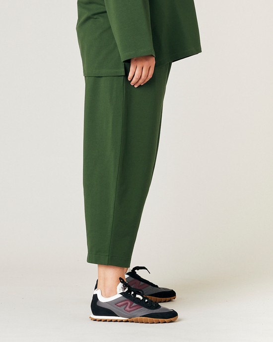 model wears kombu green jersey huxley trousers right