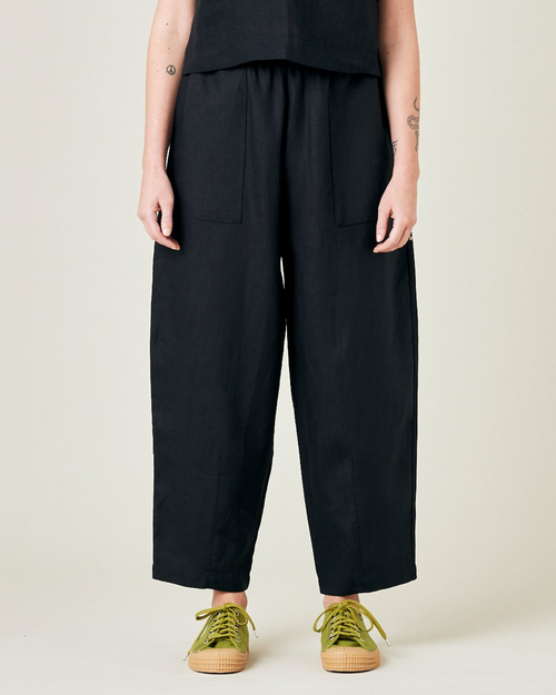 model wears longer length black linen huxley trousers