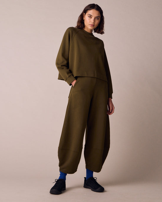 model wears earth green jersey jumper