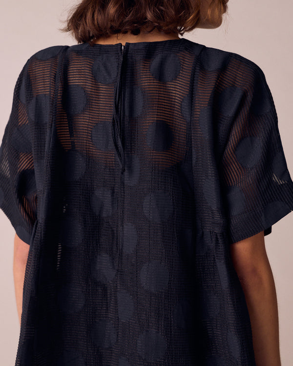 model wears zyla black sheer spot dress