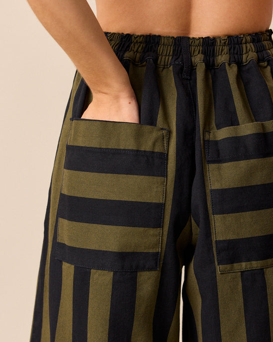 model wears blair olive and black stripe denim trousers