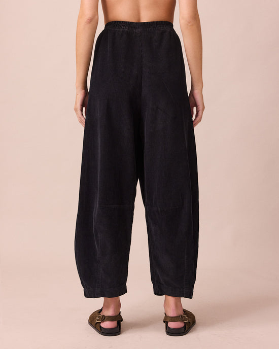 model wears daisy black cord trousers back