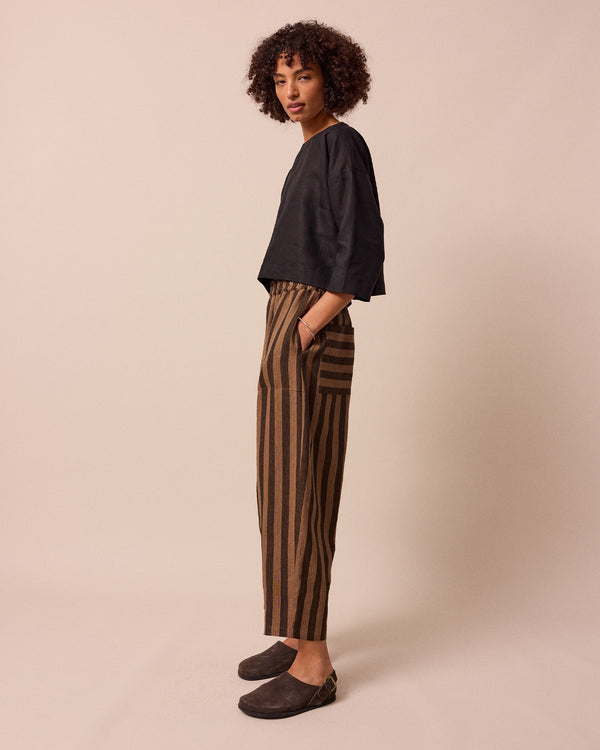 model wears walnut stripe huxley linen trousers left