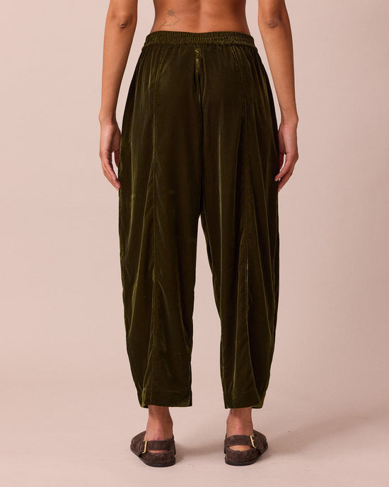 model wears mabel moss green velvet trousers back
