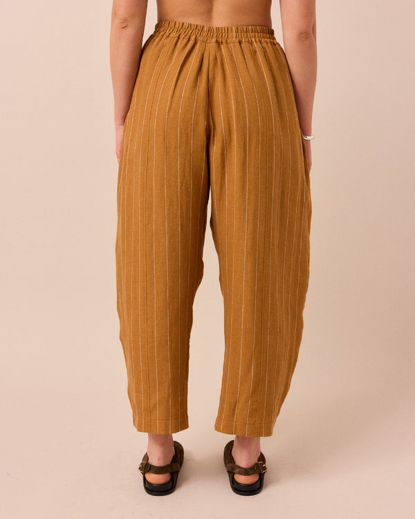 model wears honey pinstripe linen trousers back