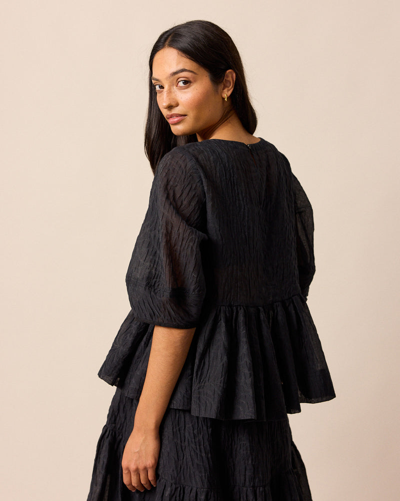 model wears priya black organza top