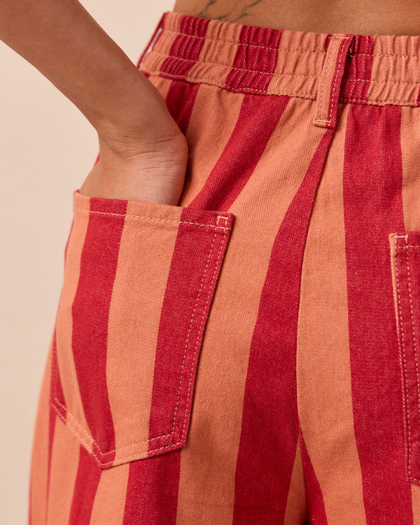 model wears peach and russet remi denim trousers