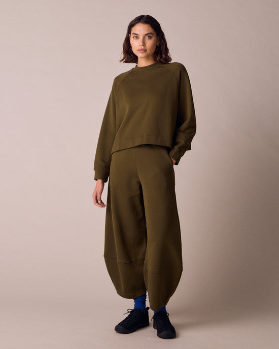 model wears pascale earth green jersey trousers right