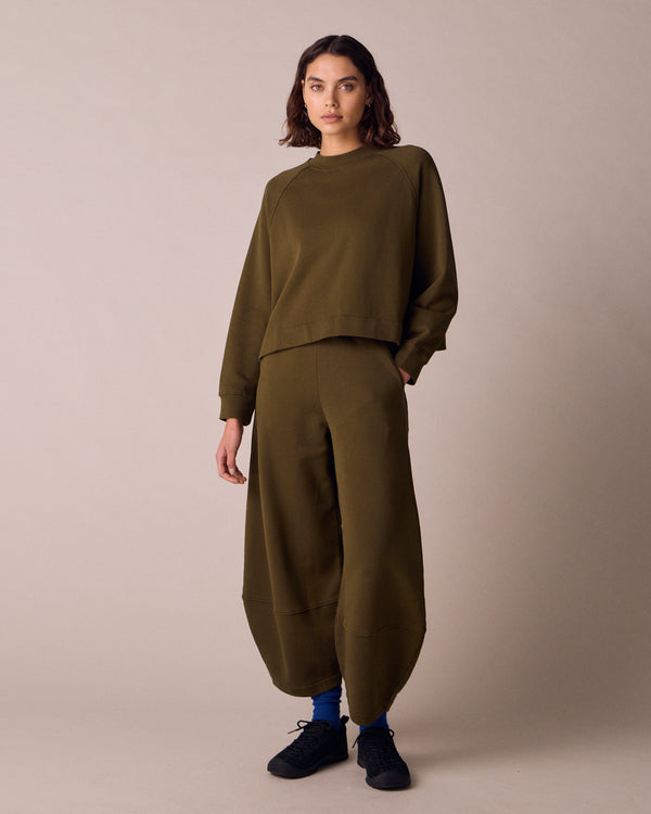 model wears pascale earth green jersey trousers right