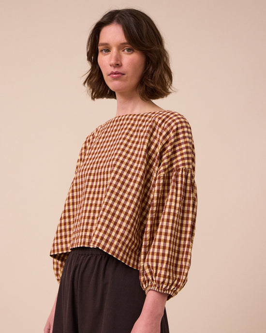 model wears aisha tan gingham seersucker top