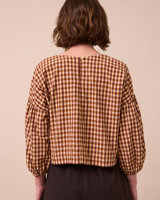 model wears aisha tan gingham seersucker top