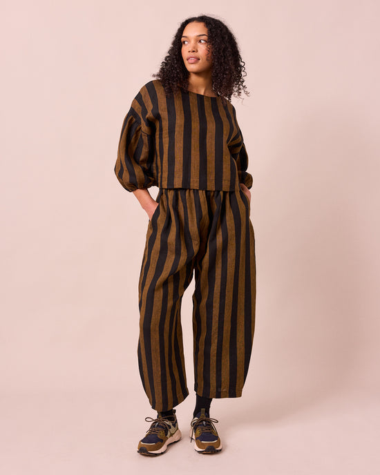 model wears aisha rust and black stripe linen top