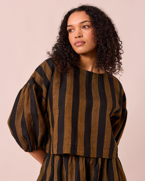 model wears aisha rust and black stripe linen top
