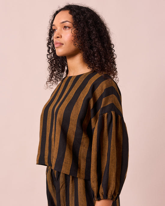 model wears aisha rust and black stripe linen top