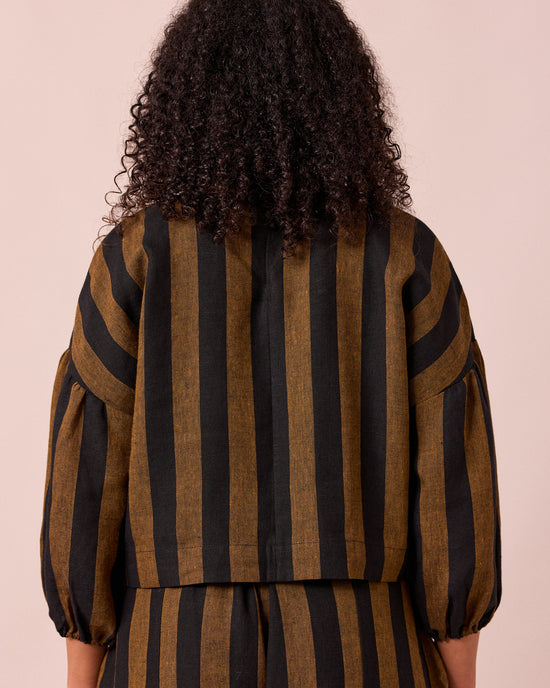 model wears aisha rust and black stripe linen top