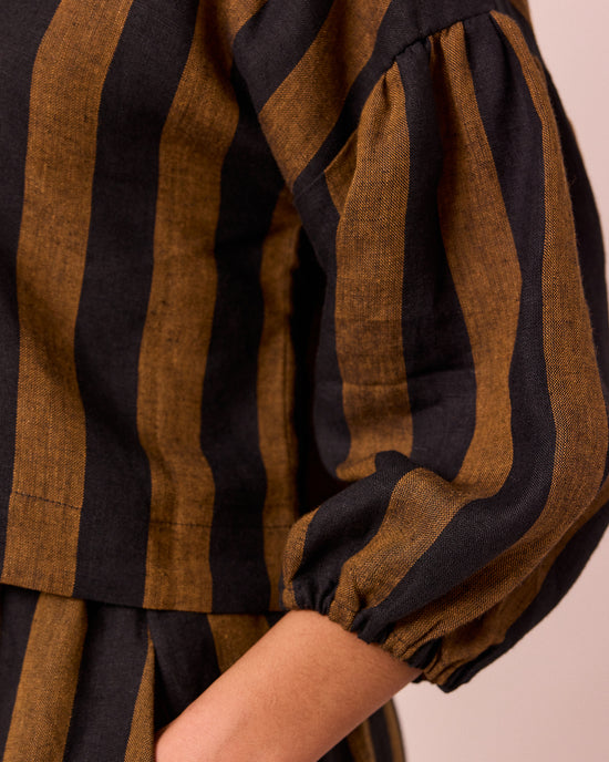 model wears aisha rust and black stripe linen top