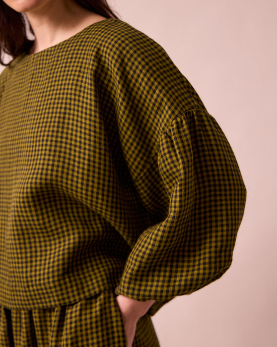 model wears the aisha fresh olive mini gingham linen top