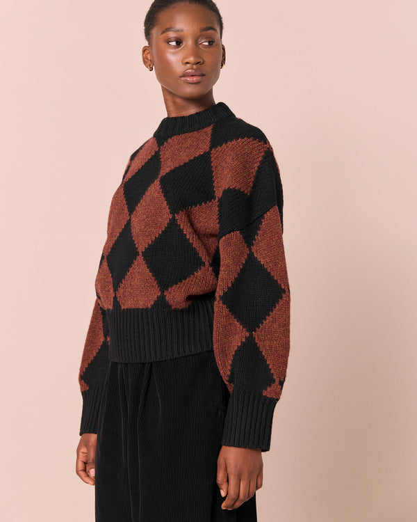 model wears alora rust harlequin knitted jumper