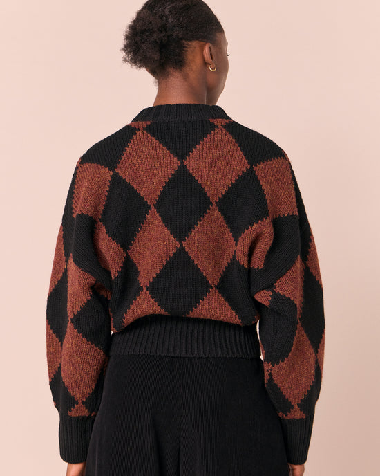 model wears alora rust harlequin knitted jumper