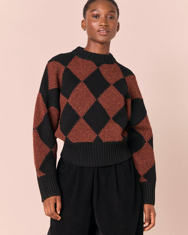 model wears alora rust harlequin knitted jumper