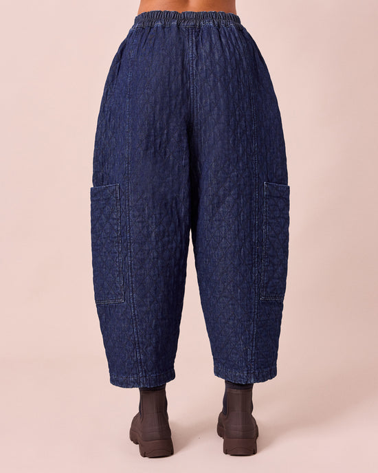 model wears amala dark blue quilted denim trousers back