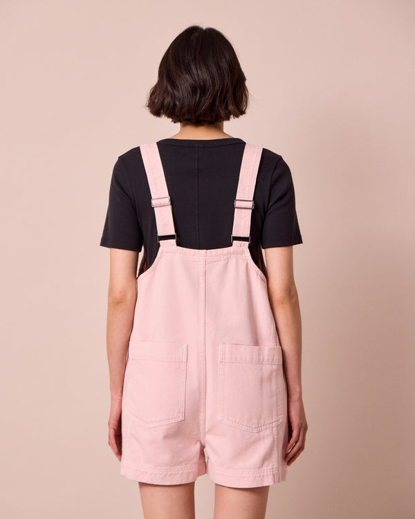 model wears anica petal pink denim playsuit