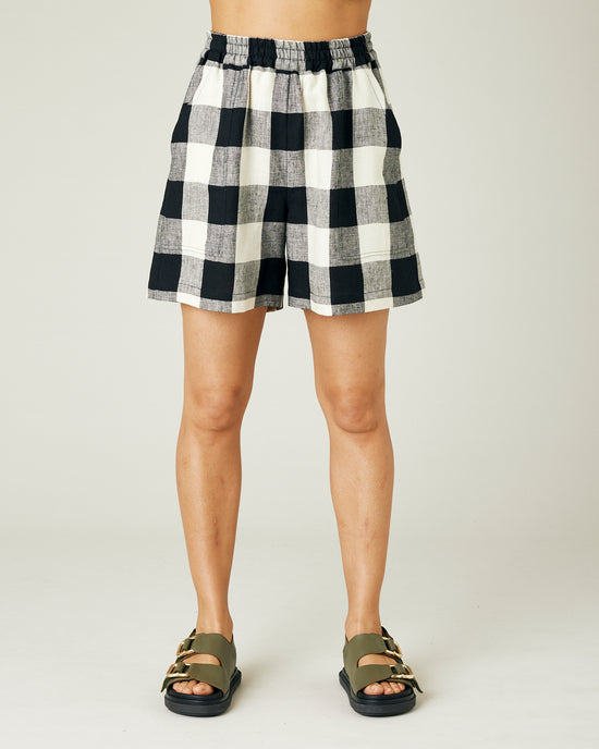 model wears stone and black check ari shorts