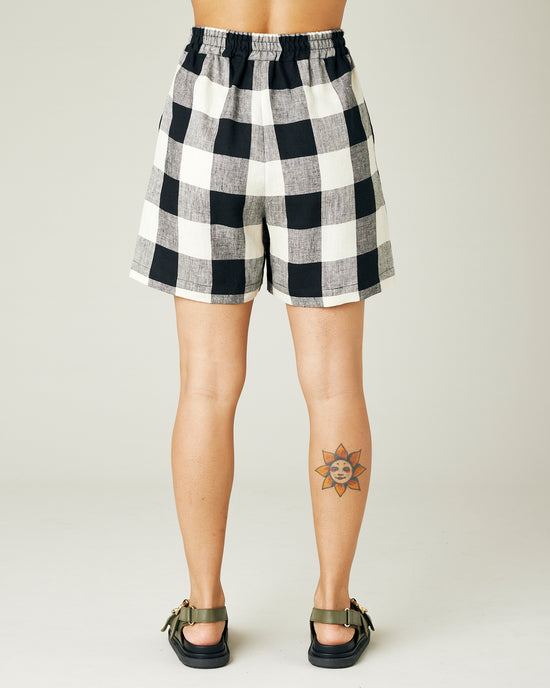 model wears stone and black check ari shorts