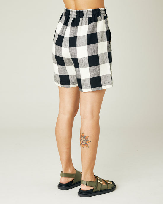 model wears stone and black check ari shorts