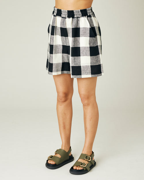 model wears stone and black check ari shorts