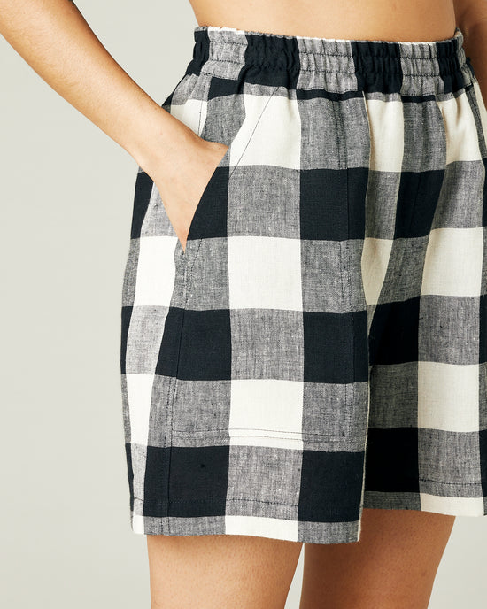 model wears stone and black check ari shorts