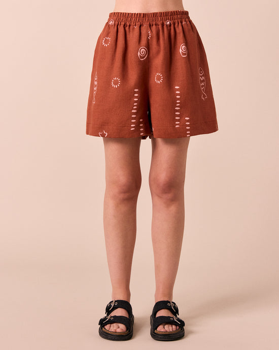 model wears arielle beachcomber print linen shorts. 
