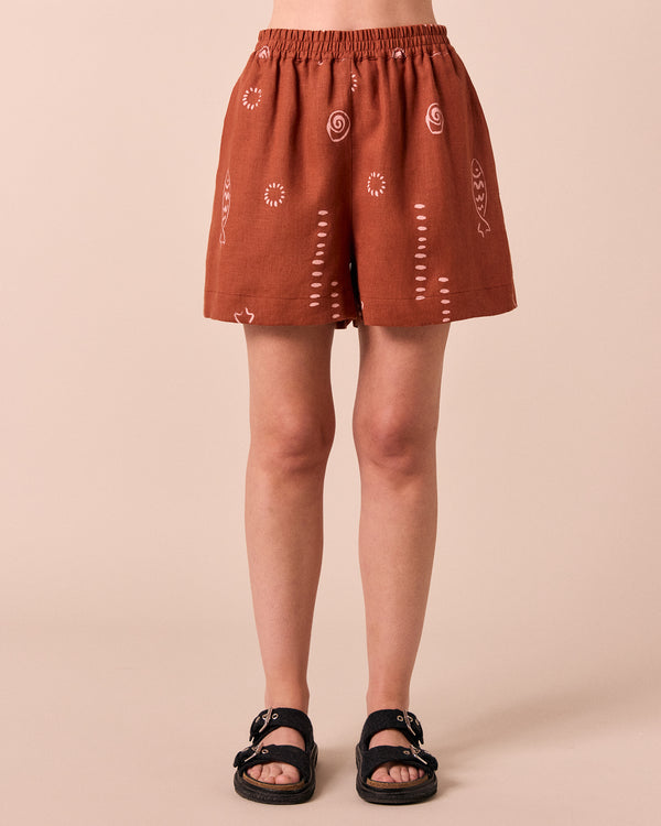 model wears arielle beachcomber print linen shorts. 