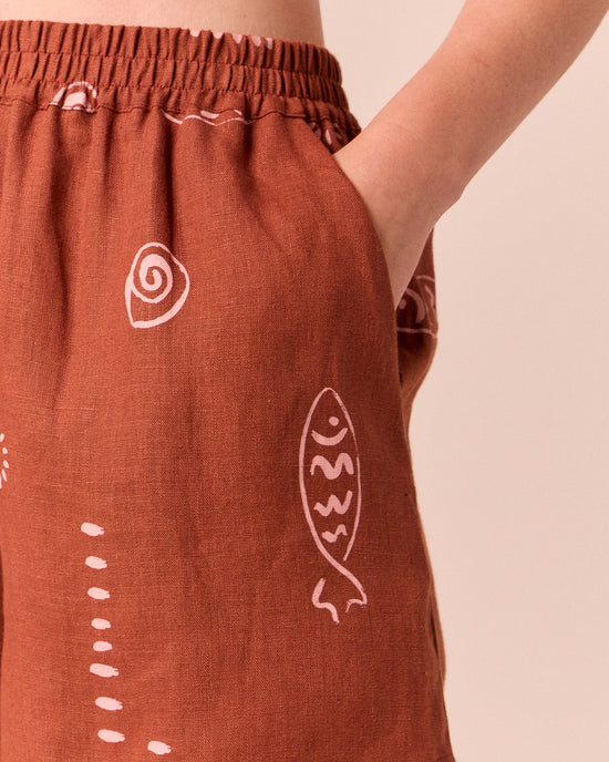 model wears arielle beachcomber print linen shorts. 