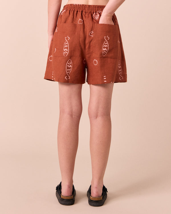 model wears arielle beachcomber print linen shorts. 