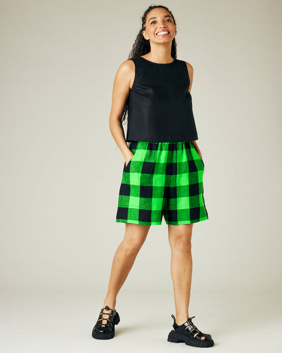 model wears green and black check ari shorts