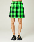 model wears green and black check ari shorts