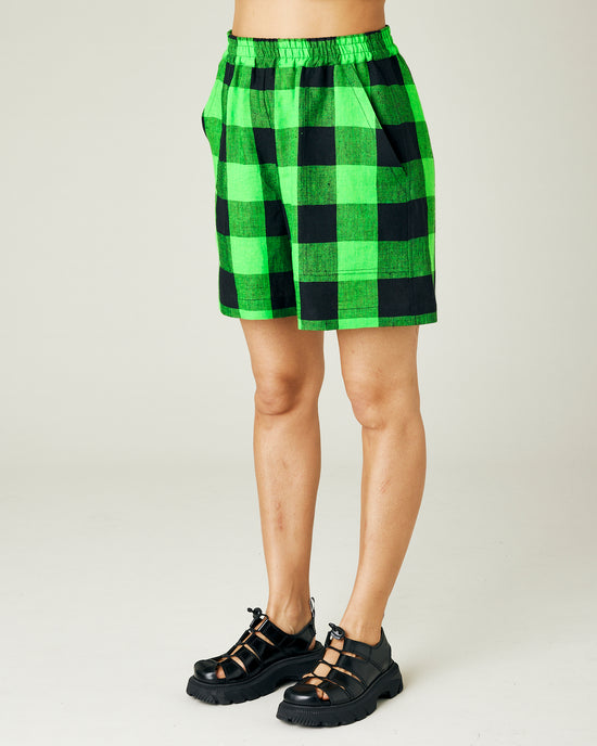 model wears green and black check ari shorts